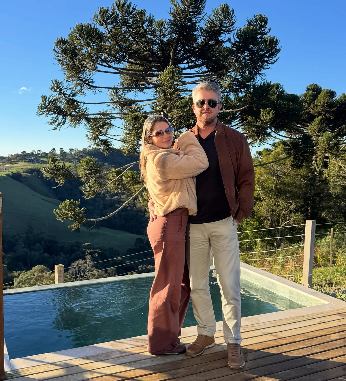 Casal diante da piscina e da paisagem da Serra Catarinense