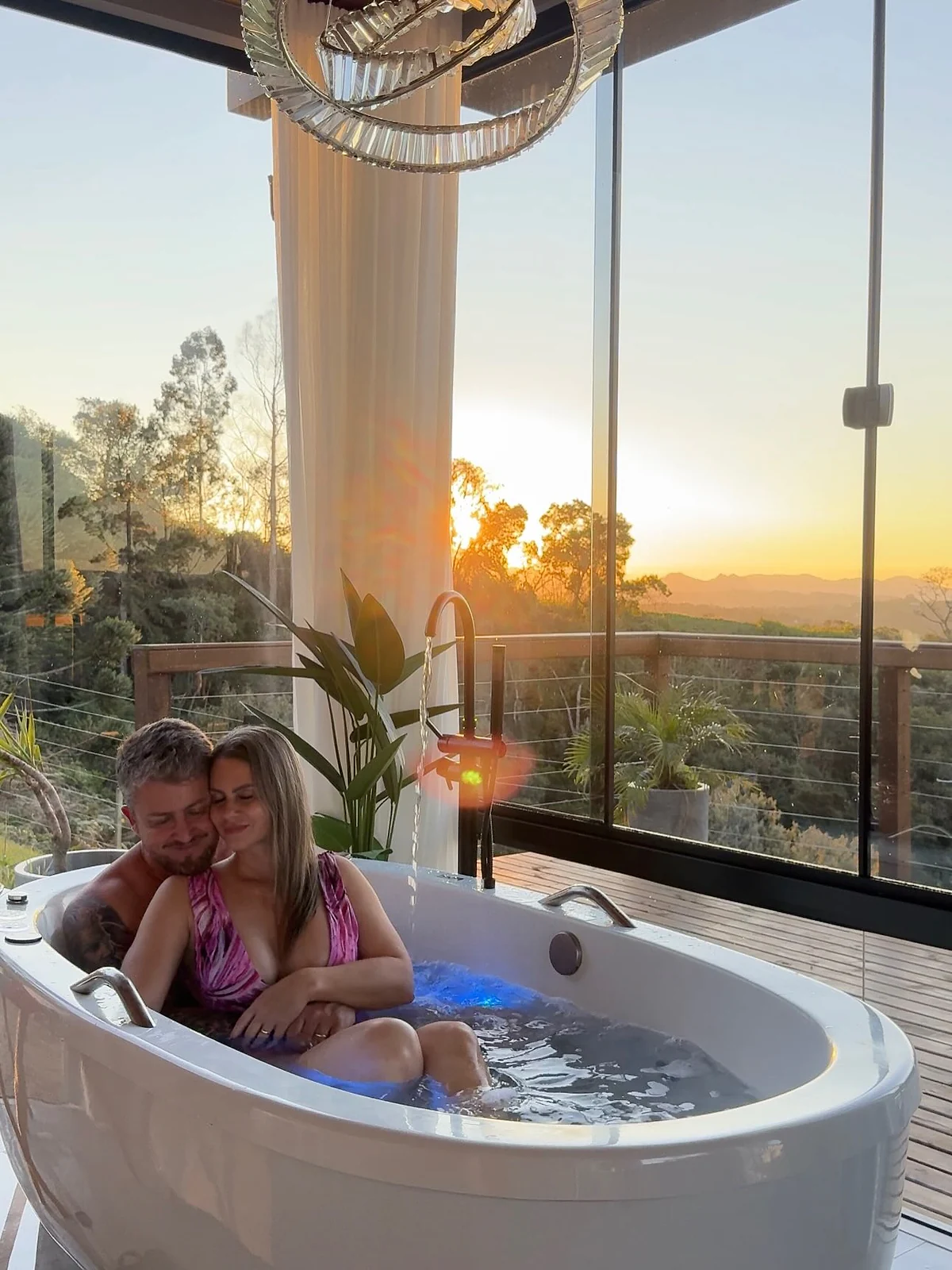 Casal relaxando na hidromassagem durante o pôr do sol