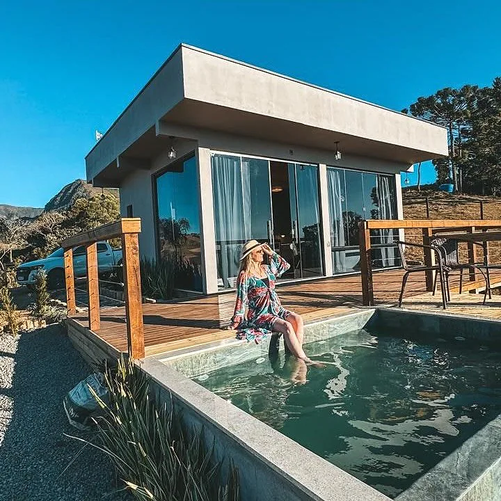 Hóspede aproveitando a piscina em frente à cabana