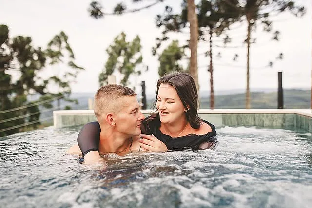Casal aproveitando junto a piscina aquecida da cabana