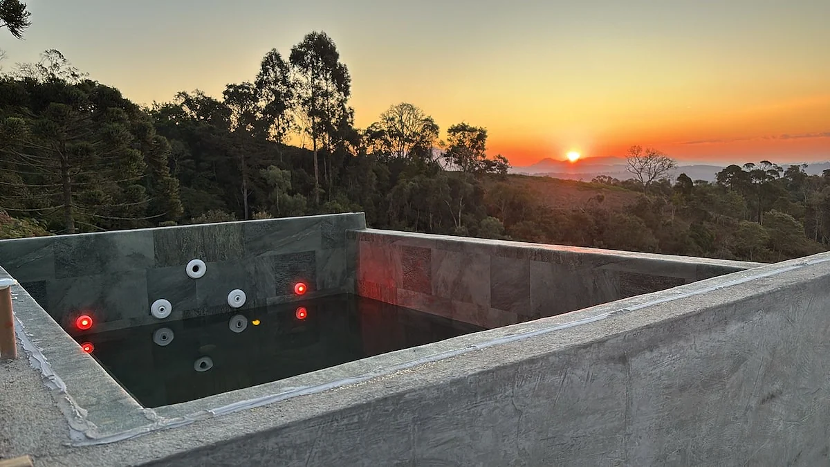 Piscina da cabana diante do pôr do sol na serra